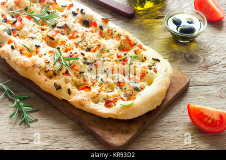 Traditionelle italienische Focaccia mit Tomaten, schwarzen Oliven und Rosmarin - Focaccia hausgemachtes Fladenbrot Stockfoto