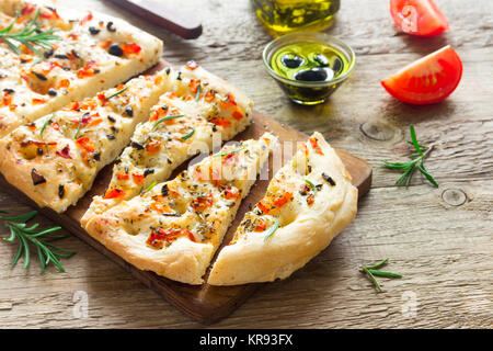 Traditionelle italienische Focaccia mit Tomaten, schwarzen Oliven und Rosmarin - Focaccia hausgemachtes Fladenbrot Stockfoto