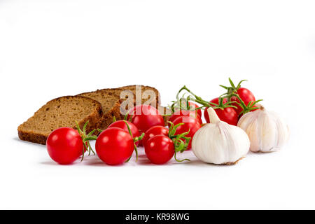 Zusammensetzung der schwarzen Scheiben Brot, Bündel von Cherry Tomaten, Knoblauch Stockfoto