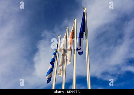 Zypern, Griechenland, der EU und der Gemeinde Larnaka Fahnen Fahnenmasten. Bewölkter Himmel Hintergrund. Stockfoto