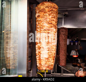 Gyros, Döner Grill langsam drehenden Spieß. Unscharfer Hintergrund. Stockfoto