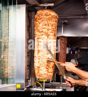 Gyros, Döner Grill langsam drehenden Spieß. Unscharfer Hintergrund. Stockfoto