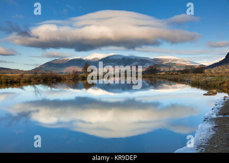 Die schneebedeckten Skiddaw im Fluss Derwent, die englischen Lake District in Großbritannien wider Stockfoto