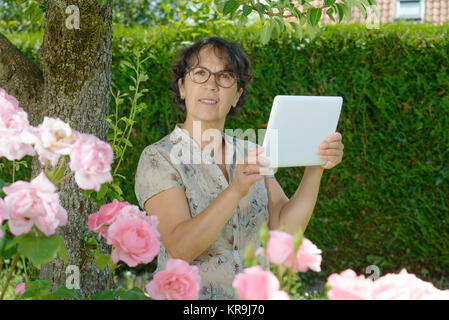 Reife Frau mit einem Tablett in den Garten Stockfoto