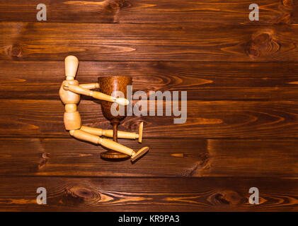 Holz- Mann mit Glas Wein Stockfoto