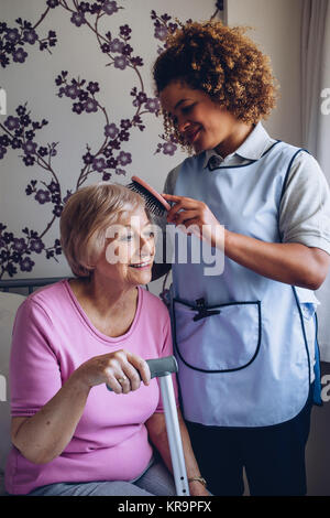 Pflegeperson Bürsten Patienten Haar Stockfoto
