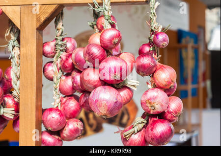 Rote Zwiebel Zöpfen in Italien in den Bauernmarkt verkauft. Stockfoto