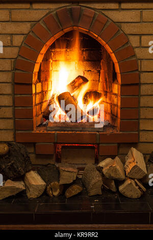 Holz- Protokolle und Feuer im Kamin Stockfoto