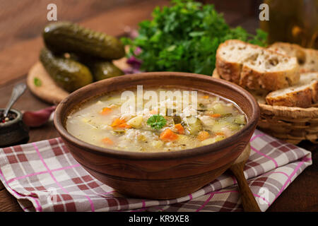 Suppe mit salzgurken und Graupen- rassolnik auf einem hölzernen Hintergrund. Stockfoto