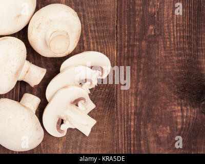 Frische weiße Champignons Pilze hautnah auf hölzernen Hintergrund Stockfoto