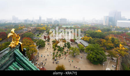 Luftaufnahme von Menschen mit bunten Sonnenschirme in Osaka Castle Park site mit Dachterrasse Elemente der Burg von Osaka. Panoramablick Herbst Landschaft auf einem beautifu Stockfoto