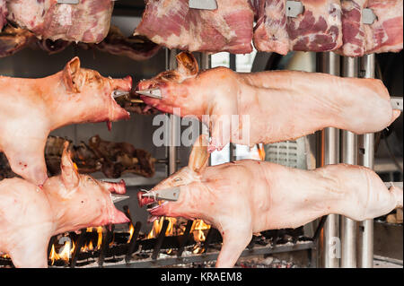 Schlachtkörper von Schweinefleisch und anderen Fleisch am Spieß zubereitet. Kochen am Grill und Feuer. Stockfoto