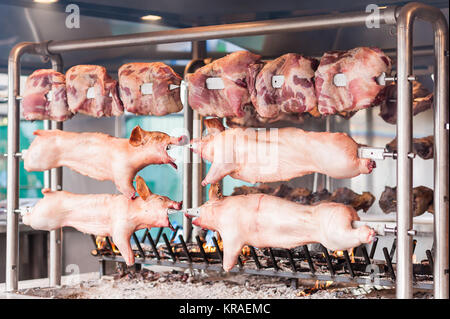 Schlachtkörper von Schweinefleisch und anderen Fleisch am Spieß zubereitet. Kochen am Grill und Feuer. Stockfoto