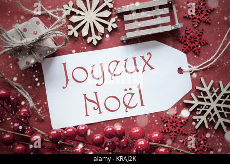 Nostalgische Weihnachten Dekoration wie Geschenk oder Präsent, Schlitten. Karte für Seasons Greetings mit rotem Papier Hintergrund. Französische Text Joyeux Noel bedeutet Frohe Weihnachten Stockfoto