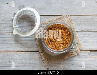 Raw braune Hirse in einem Glas Stockfoto