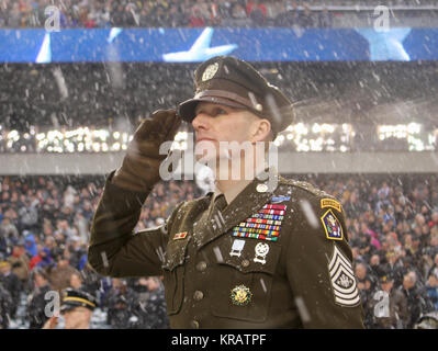 Sergeant Major der Armee Dan Dailey begrüßt die Hymne vor dem Start während der Army-Navy Spiel bei Lincoln Financial Field in Philadelphia, Pennsylvania, Dez. 9, 2017. SMA Dailey angezeigt, die Armee des vorgeschlagenen "Rosa und Grün" Daily service Uniform, modelliert nach Standard der Armee aus der Zeit des Zweiten Weltkriegs Dress Uniform. (U.S. Armee Stockfoto