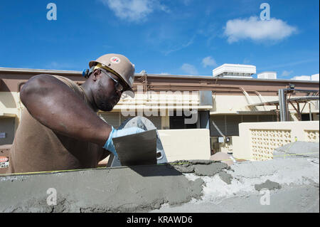 U.S. Navy Builder Constructionman Paul Richardson, zu Naval Mobile Konstruktion Bataillon (NMCB) 133, Zement Formen während der Verarbeitung eines Generators Stützmauer am Marinestützpunkt Guam Dezember 13, 2017 zugeordnet. NMCB-133 wird bereitgestellt, bereit, größeren Kampfhandlungen, die humanitäre Hilfe zu unterstützen und Disaster Relief operations. Sie stellen General Engineering und der Unterstützung der Navy, Marine Corps und gemeinsamen operativen Kräfte. (U.S. Marine bekämpfen Kamera Stockfoto