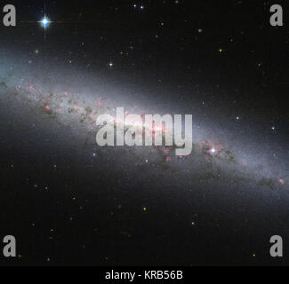 Dieses Bild zeigt einen wunderschönen Blick auf die Galaxie NGC 7090, die von der NASA/ESA Hubble Space Teleskop gesehen. Die Galaxie ist der Kante von der Erde aus gesehen, d. h. wir können leicht sehen, die Spiralarme, die voll sind von jungen, heißen Sternen. Aber unsere Seitenansicht zeigt die Scheibe der Galaxie und die pralle zentralen Kern, wo in der Regel eine große Gruppe von Cool alte Sterne in einem kompakten verpackt werden, Sphäroguss Region. Darüber hinaus gibt es zwei interessante Features im Bild vorhanden, die erwähnenswert sind. Zuerst sind wir in der Lage, ein verschlungenes Muster von Rosarot Regionen über die gesamte GAL zu unterscheiden. Stockfoto
