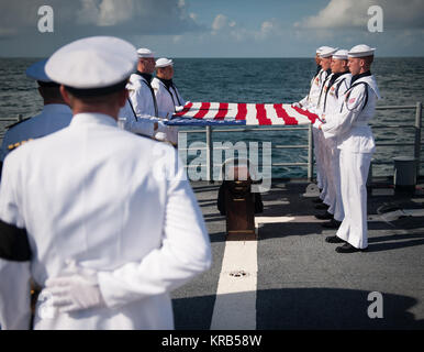 Mitglieder der US Navy zeremoniellen Wache halten eine amerikanische Flagge über dem cremains von Apollo 11 Astronaut Neil Armstrong während einer Bestattung auf See Dienst an Bord der USS philippinischen Meer (CG58), Freitag, Sept. 14, 2012, in den Atlantischen Ozean. Armstrong, der erste Mensch auf dem Mond während der Apollo 11 Mission 1969, gestorben Samstag, 12.08.25. Er war 82. Photo Credit: (NASA/Bill Ingalls) Neil Armstrong Bestattung auf See (201209140008 HQ) Stockfoto