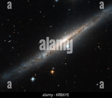 Diese dünne, glitzernde Streifen von Stars ist die spiralförmige Galaxie ESO 121-6, die im südlichen Sternbild Pictor Staffelei (des Malers liegt). Gesehen fast genau auf der Seite, die komplizierte Struktur der wirbelnden Armen verborgen ist, aber die volle Länge der Galaxie gesehen werden kann - einschließlich der intensiven Glühen von der Zentrale Ausbuchtung, einem dichten Region dicht junge Sterne im Zentrum der Spiralarme sitzen. Ranken der dunklen Staub kann über dem Rahmen gesehen werden, teilweise verdecken der hellen Zentrum der Galaxis und weiter in Richtung Brocken von Sternen in der Kanten, wo Stockfoto