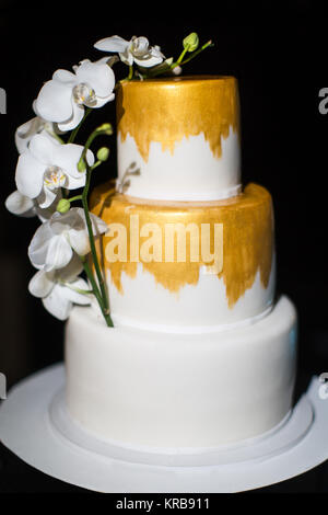 Multi Level Hochzeitstorte mit mit weißen Orchideen. Stockfoto