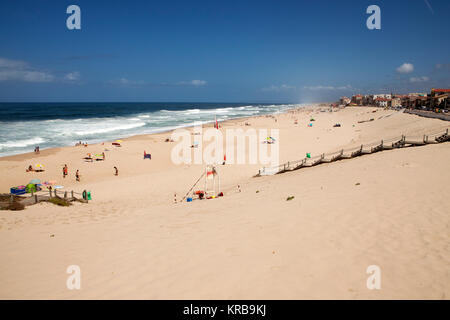 Badende am Strand von Marinha Grande, Portugal. Holz- Stufen führen hinunter auf den Sandstrand. Stockfoto