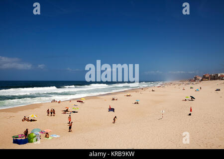 Badende am Strand von Marinha Grande, Portugal. Den Atlantik Runden gegen den Sandstrand. Stockfoto