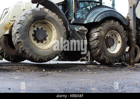 Lkw starke Outrigger Stabilisierung Beine erweitert. Traktor auf erweiterte Stützen für bessere Stabilität, graben Sie einen Eimer von der Straße zur Reparatur. Reportage Fotografie. Stockfoto