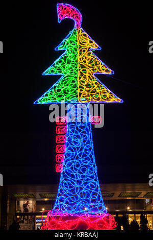 Die hellen bunten Weihnachtsbaum leuchtet von Marco Lodola, Venedig, Italien vor dem Santa Lucia Bahnhof bei Nacht mit Silhouetten von touristischen Stockfoto