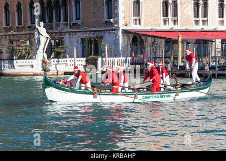 Feiern Weihnachten in Venedig, Italien während der babbo Natale regatta Parade, Grand Canal mit Menschen in rot Santa Kostüme Ruderboote Stockfoto