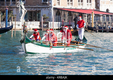 Feiern Weihnachten in Venedig, Italien während der babbo Natale regatta Parade, Grand Canal mit Menschen in rot Santa Kostüme Ruderboote Stockfoto