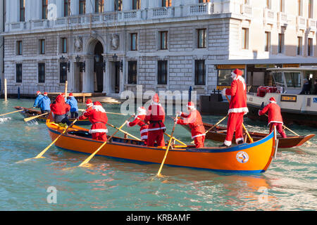 Feiern Weihnachten in Venedig, Italien während der babbo Natale regatta Parade, Grand Canal mit Menschen in rot Santa Kostüme Ruderboote Stockfoto