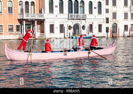 Feiern Weihnachten in Venedig, Italien während der babbo Natale regatta Parade, Grand Canal mit Menschen in rot Santa Kostüme Ruderboote Stockfoto