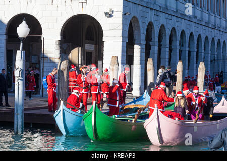 Feiern Weihnachten in Venedig, Italien während der babbo Natale regatta Parade, Grand Canal mit Menschen in rot Santa Kostüme in coarlina Boote bei Ria Stockfoto