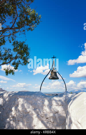 Bronzene Glocke mit Kreuz an der Wand von Tsambika Kloster (Rhodos, Griechenland) Stockfoto