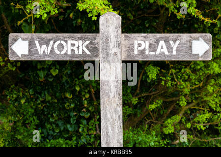 Arbeit versus spielen Wegweiser Stockfoto