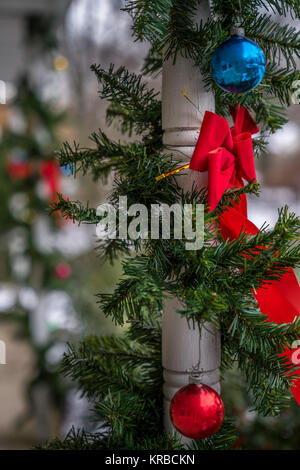 Rad Bow Tie, Weihnachtsschmuck und immergrünen Dekoration hängen an den Wald Spalte. Traditionelle Feier, Weihnachtszeit und Weihnachten conce Stockfoto