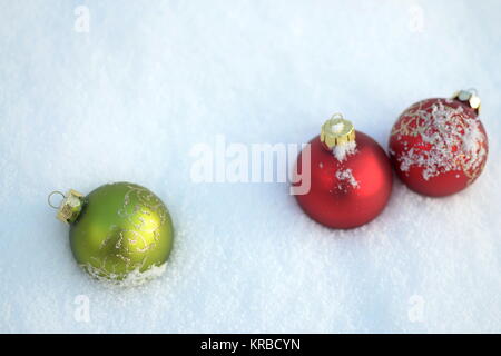 Drei Weihnachtskugeln liegen im Schnee Stockfoto