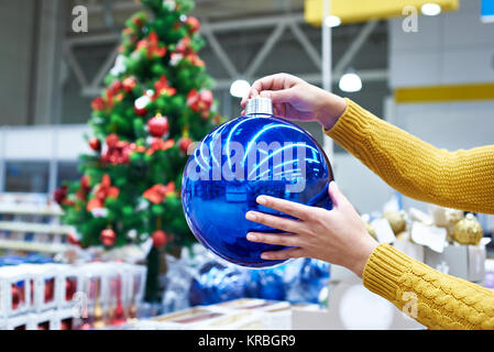 Große blaue Weihnachtsbaum Kugel in weibliche Hände Stockfoto