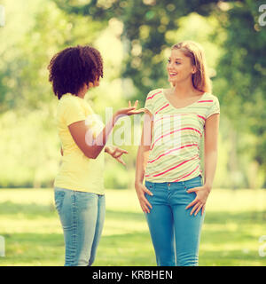 Zwei junge Frauen sprechen in Park Stockfoto