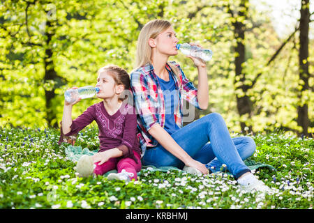 Zwei Schwestern Trinkwasser auf Sommertag im Park Stockfoto