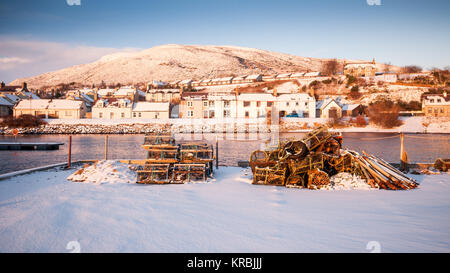 Hummer Töpfe liegen unter unberührten Schnee auf dem Meer Wand von Helmsdale Hafen an der Küste von Moray Firth Sutherland im nördlichen Hochland von Sc Stockfoto