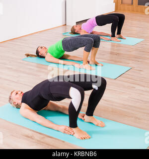 Drei Mädchen üben Yoga, Setuasana/Little Bridge stellen Stockfoto