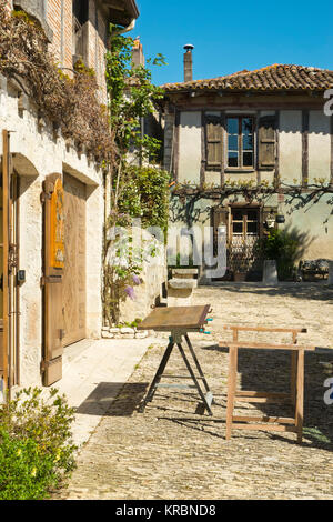 Traditionelle hölzerne Fensterläden, repariert und neu lackiert warten auf eine Werkbank außerhalb einer idyllischen alten Cottage in Pujols, Lot-et-Garonne, Frankreich Stockfoto