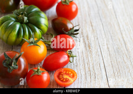 Bunte Tomaten auf einem Holztisch Stockfoto