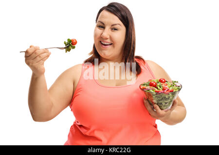Übergewichtige Frau essen einen Salat auf weißem Hintergrund Stockfoto