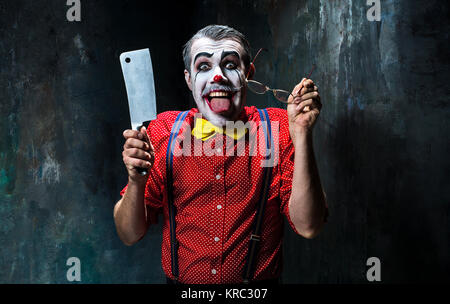 Der gruselige Clown mit einem Messer auf Dack. Halloween-Konzept Stockfoto