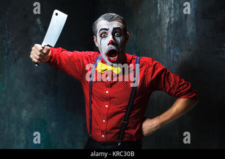 Der gruselige Clown mit einem Messer auf Dack. Halloween-Konzept Stockfoto