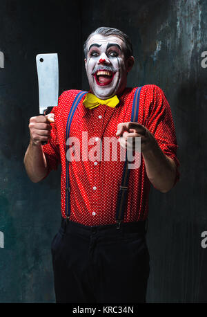 Der gruselige Clown mit einem Messer auf Dack. Halloween-Konzept Stockfoto