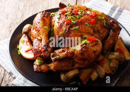 Festliche Essen: Gebratenes Huhn mit Pilzen und Kartoffeln close-up auf einem Teller auf dem Tisch. Horizontale Stockfoto